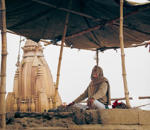 A mesmerizing view of the Ghats of Varanasi at sunrise, with boats floating on the Ganges River and temples lining the banks. This image beautifully captures the spiritual and historical essence of Varanasi, perfect for Varanasi tour packages. It highlights the best time to visit Varanasi, featuring famous places like the Kashi Vishwanath Temple and Dashashwamedh Ghat. The image also hints at the famous food of Varanasi, such as kachori, chaat, and lassi, while providing a glimpse of how to reach Varanasi for a deep cultural and historical experience.